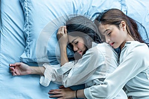 Top view of two Asian women sleeping on bed together. Lesbian lovers and couple concept. People and lifestyles theme