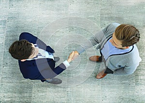 Top view of a two businessman shaking hands. Welcome to business.