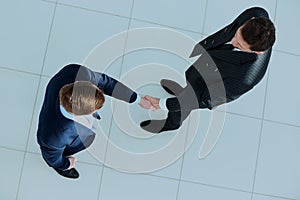 Top view of a two businessman shaking hands - Welcome to business.
