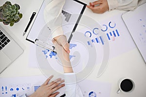 Top view of two businesspeople shaking hand during the financial meeting. business negotiation