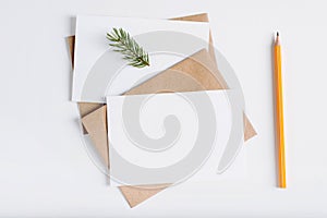 Top view two christmas blank greeting cards mock-up. Craft envelopes, pine twig, pencil and card with empty space for text
