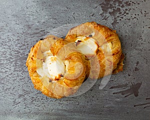 Top view of two delicious cream cheese danishes on a gray mottled tabletop