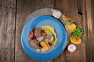 Top view of two grilled lamb chops and potatoes served on pea puree with a mint sauce