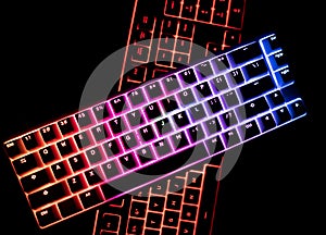 Top view of two illuminated RGB keyboards in the dark