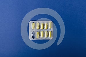 Top view of two-piece capsules in the blister pack on the dark blue background.Empty space