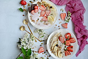 Top view of two plates with muesli, porridge, yogurt and strawberries on a lilac background. Healthy and nutritious
