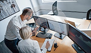 Top view. Two stockbrokers in formal clothes works in the office with financial market