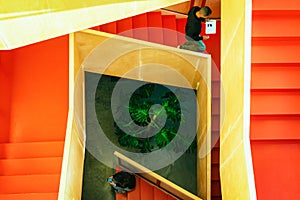 Top view of two young people with their mobile devices on the staircase inside of the building - Image