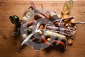 Top view of typical spanish sausages and red and white wine on wooden
