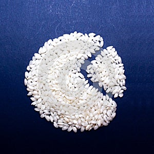 Top view of uncoocked rice grains on the blue background