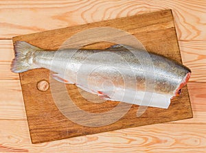 Top view of uncooked arctic char carcass on cutting board