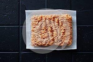 A top view of a raw chicken mince on placed on the white napkin  on the black table