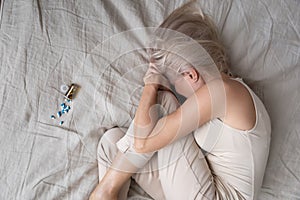 Top view of unhappy senior woman lying in bed suffering