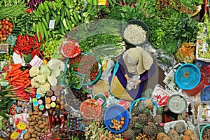 Top view of unidentified woman selling vegetables.