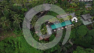 Top view of unrecognizable slim young woman in beige bikini relaxing and sunbathe near luxury swimming pool in green