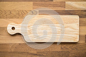 Top view of unused brand new bro wn handmade wooden cutting board on wooden table background