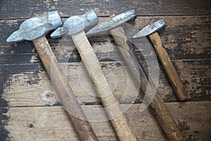 Top view used hammers of different sizes on a wooden surface. Carpentry home repair tool Selective focus