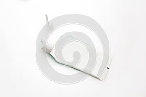 Top view of used toothpaste on a white background