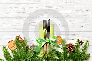 Top view of utensils on festive napkin on wooden background. Christmas decorations with dried fruits and cinnamon. New year dinner