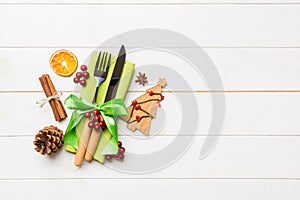 Top view of utensils on festive napkin on wooden background. Christmas decorations with dried fruits and cinnamon. New year dinner