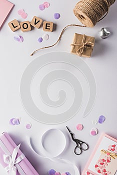 Top view of valentines decoration, gifts, handiwork supplies and love lettering on cubes on white background