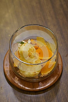 top view vanilla ice cream and orange slices in a glass bowl on a wooden tray, on wooden table background, food, dessert, copy