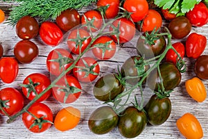 Top view of varicolored cherry tomatoes on old wooden surface