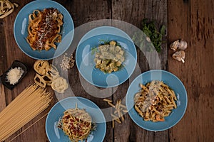 Top view variety of homemade prepared pasta isolated on wooden table