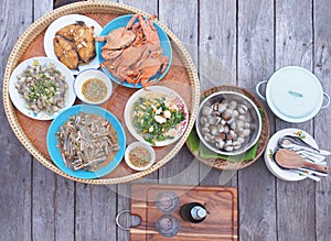 Top view of Variety Thai seafood set served on bamboo tray over wooden table