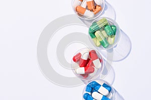 top view of various colorful pills in plastic bowls