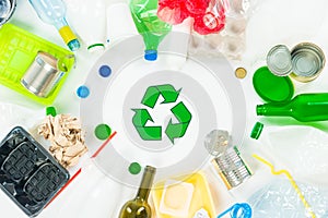 Top view of various types of trash surrounding recycle sign photo