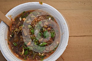 Top view of veg manchurian with spring onions on wooden table