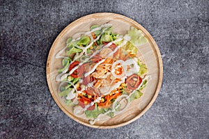 Top view vegetables salad with shrimps on concrete table.