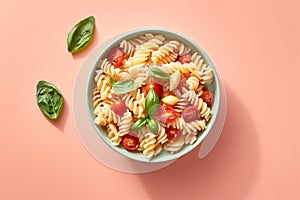Top view of vegetarian pasta bowl with fusilli, tomato and basil