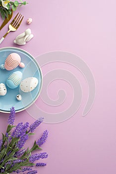 Top view vertical photo of blue plate with easter eggs cutlery ceramic rabbit and bunch of lavender flowers