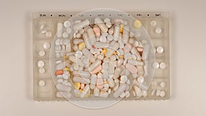 TOP VIEW: Very many pills lie in a pill dispenser