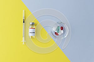top view of vial with vaccine and syringe on yellow background, plate with pills on grey background, comparison of two methods of
