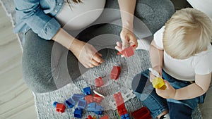 Top view video of  mother playing toy blocks with son