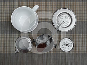 Top view of vietnamese coffee filter ingredients with ready cup of coffee on bamboo placemat