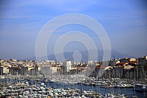 Top view of the Vieux Port of Marseille, with the mountains in the background