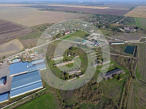 Top view of the village. One can see the roofs of the houses and gardens. Top view of the village with houses and hangars for the