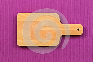 Top view vintage cutting wood board on purple tablecloth background