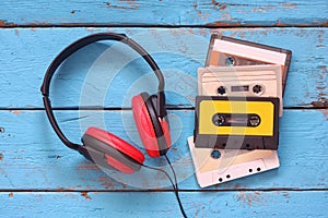 Top view of vintage headphones and cassettes over aqua wooden table. retro filtered