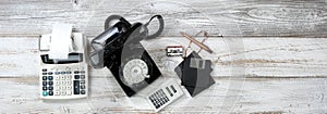 Top view of Vintage technologies that includes rotary dial phone and old computer data storage devices plus calculators