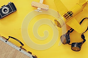 Top view of vintage yellow toy plane, old photo camera