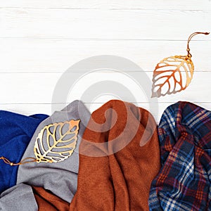 Top view on warm woolen scarf and decorated autumn leaves. Beginning fall concept