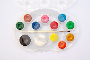 Top view of a watercolor school paintbox. Paint palette with brush. Back to school supplies concept. photo