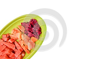 Top view of watermelons, papayas and dragon fruits in a green plate over white background