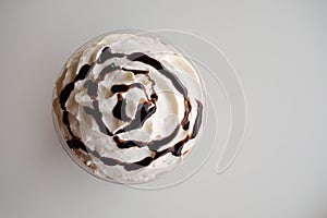 Top view of whipping cream with chocolate syrup on white background
