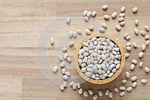 Top view of white beans in a bowl on wooder background, Healthy eating concept
